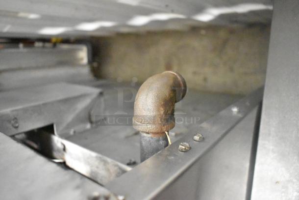 Close-up of a metal pipe component on an American Range stainless steel commercial 6 burner range, showing light wear.