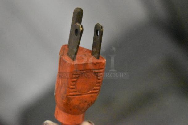 The image shows a red electrical plug, part of a metal commercial countertop electric-powered meat tenderizer, 115 volts, 1 phase.