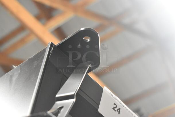 Close-up of a metal bracket on the 2025 True FLM-81F Commercial 3 Door Reach-In Freezer Merchandiser. Auction tag number 24 visible.