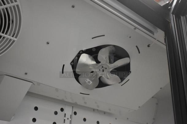 Interior of True FLM-81F freezer showing metal fan and perforated shelf. Commercial-grade, energy-efficient unit.