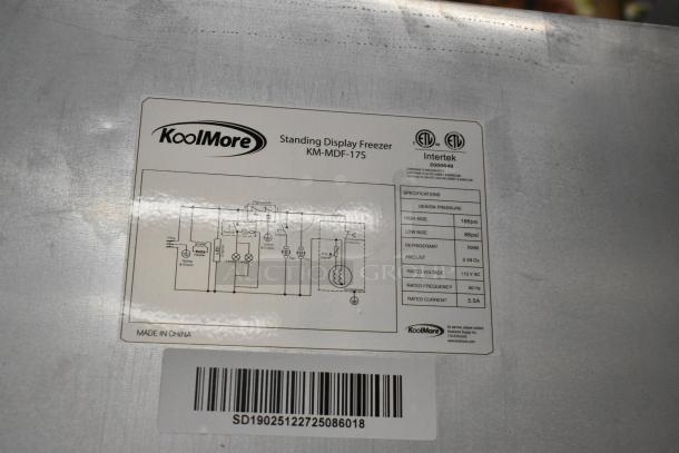 Brand new KoolMore KM-MDF-17S slim commercial merchandiser freezer, 6.5 cu. ft., manual defrost, 115V, scratch and dent condition. Labels indicate specifications and certifications.