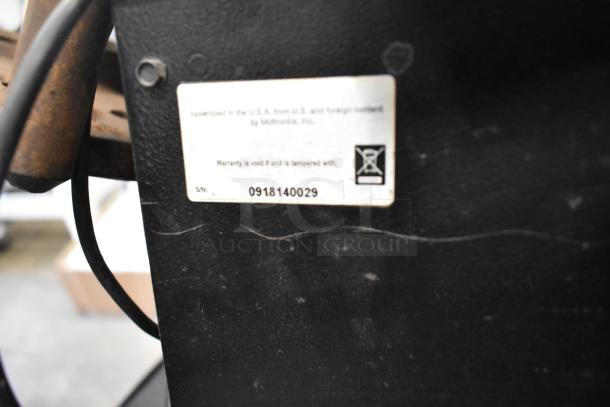 Midtronics GRB Diagnostic Station label, serial number 0918140029, warranty void if tampered. Black casing visible.