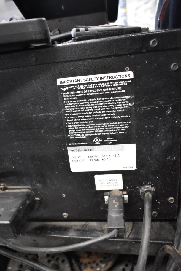 Midtronics GR8-B Battery Diagnostic Station, with visible safety instructions label, inputs 120 Vac, outputs 12 Vdc.