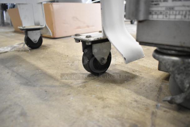 Close-up of caster wheels on Oliver 797-32NC commercial bread loaf slicer. Floor style; 115 volts, 1 phase. Slight wear visible.