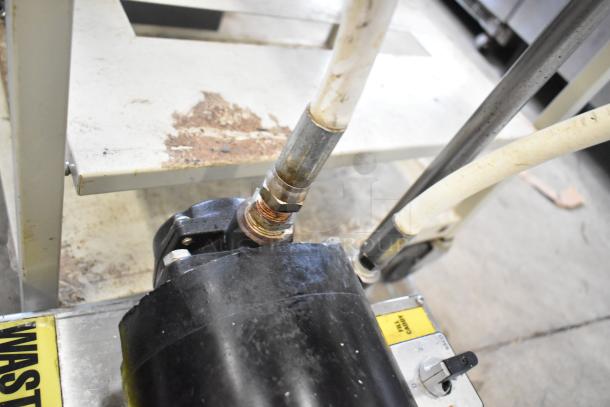 Metal fryer oil caddy on commercial casters, featuring 115/230 volts, 1 phase power. Visible wear. Tags indicate usage instructions.