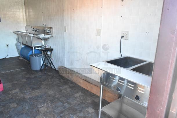 Fully outfitted food trailer interior features ServIt steam table and stainless steel sinks, ready for mobile kitchen use.
