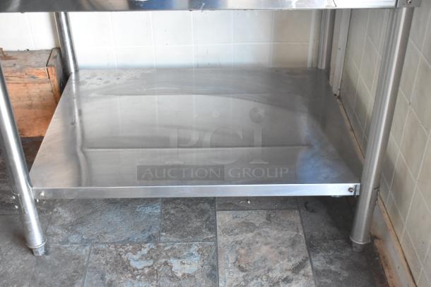 Stainless steel shelf inside a fully outfitted food trailer, part of the mobile kitchen setup, showing clean condition and metal texture.