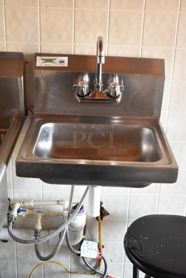 Stainless steel sink in a food trailer kitchen with dual-handle faucet, visible plumbing, and NSF certification tag.