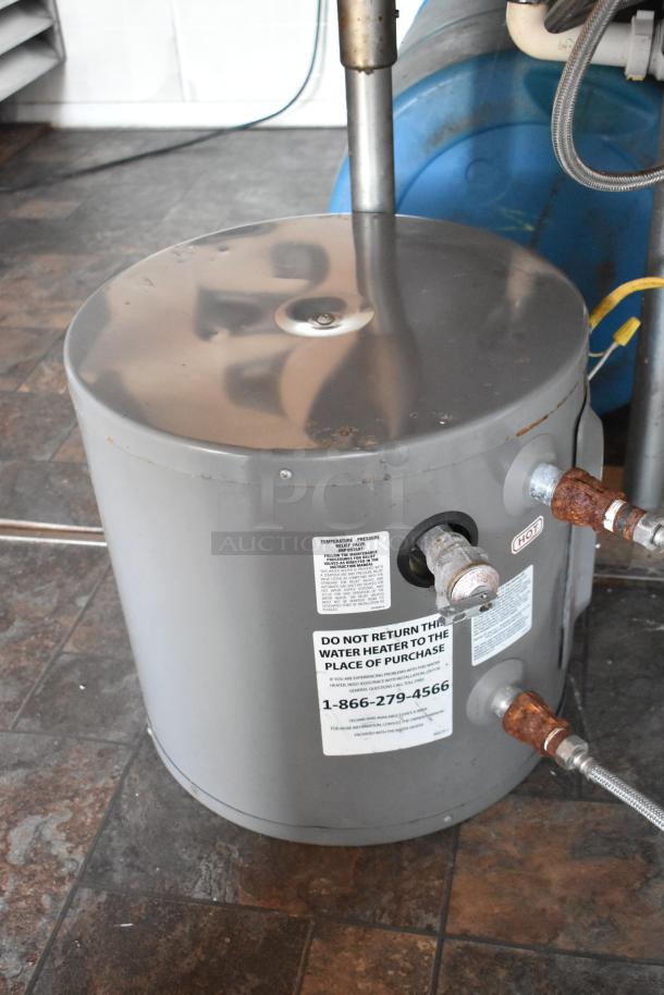 Commercial-grade water heater in mobile kitchen trailer, labeled "DO NOT RETURN" with contact number, showing pipe connections.