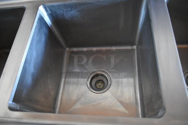 Stainless steel sink in a fully equipped food trailer's kitchen. Clean and ready for use.