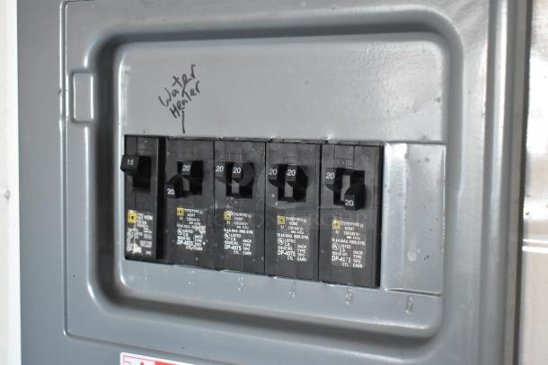 Close-up of a circuit breaker panel in a food trailer, labeled for a water heater.