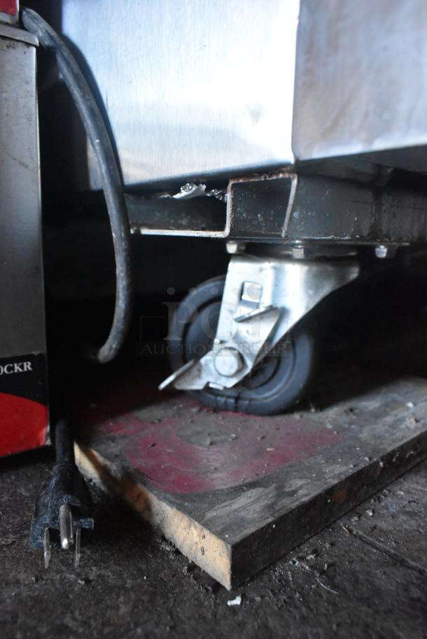 Mobile kitchen trailer wheel and plug detail, featuring secure caster and electrical connection.
