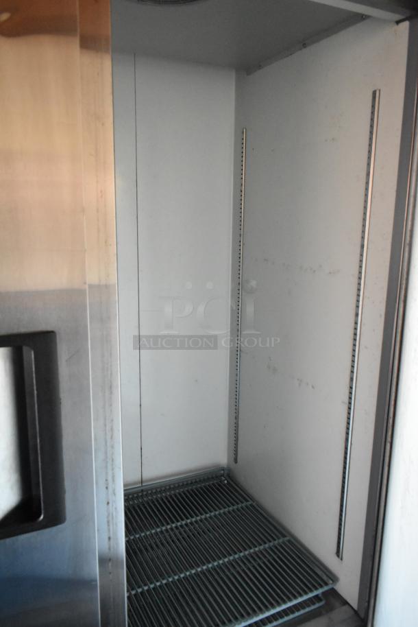 Avantco reach-in cooler interior with wire shelving, part of a fully outfitted mobile kitchen trailer.