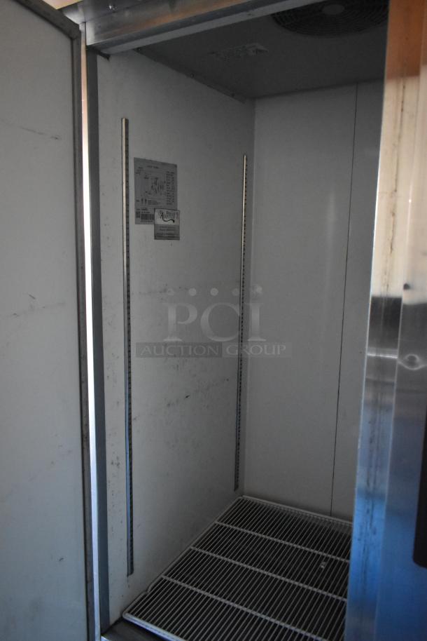 Interior of a mobile kitchen trailer featuring an Avantco reach-in cooler with metal racks and visible brand labels.