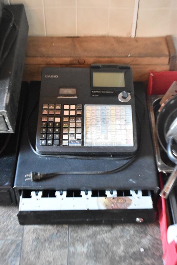 Casio SE-4460 electronic cash register, black, with open cash drawer and power cord, in used condition.