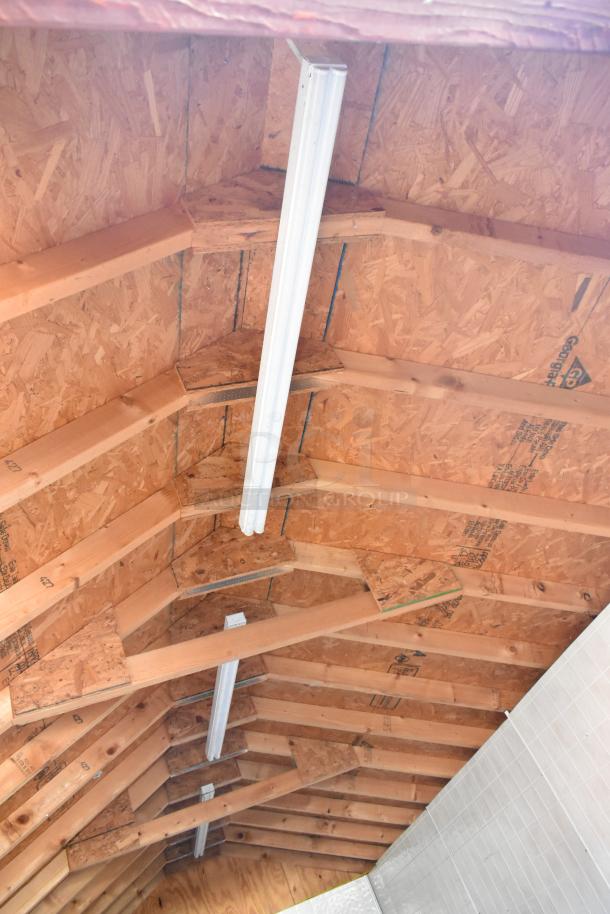 Interior ceiling view of a fully outfitted food trailer, showcasing structured wood paneling and overhead lighting fixtures.
