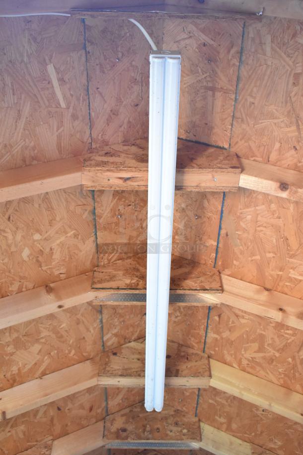 Interior view of a food trailer ceiling, showing wooden structure and fluorescent lighting fixture.