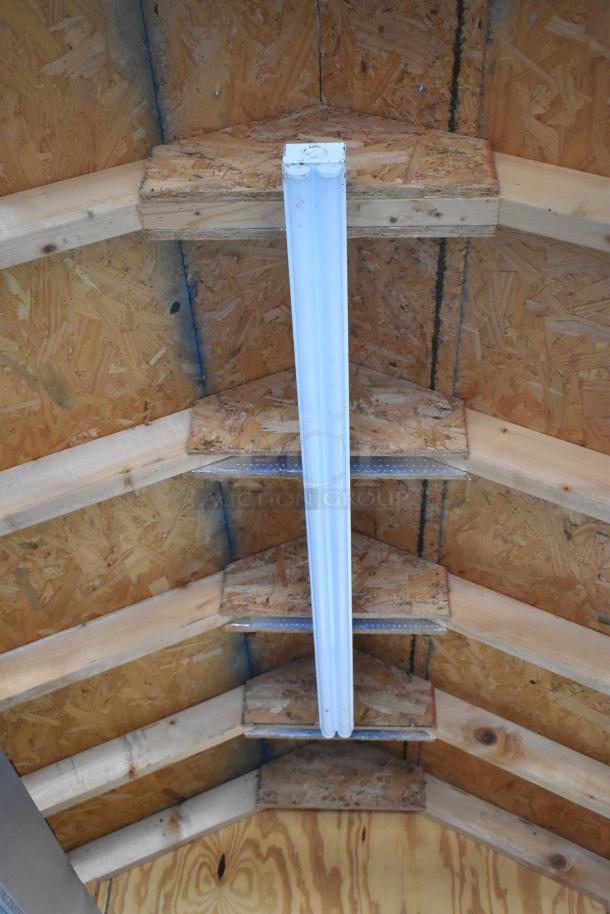 Interior view of the food trailer's wooden ceiling with a fluorescent light fixture.