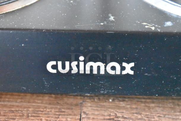 "cusimax" logo on a black surface, close-up view, showing minor scratches and wear.