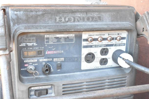 Honda EU6500is generator, used, showing control panel with switches, fuel gauge, and power outlets.