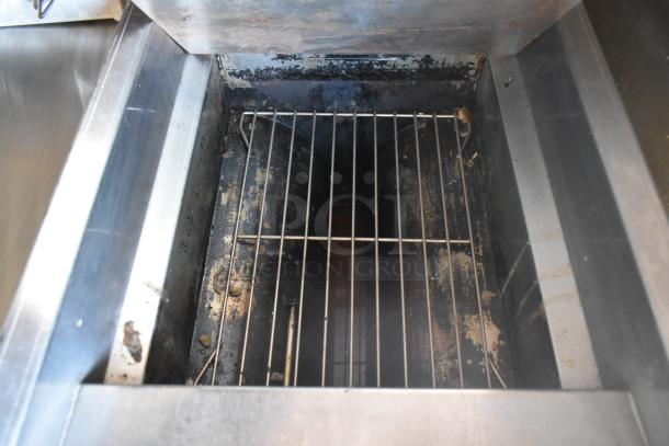 Interior view of Meadow Creek barbecue grill with metal grates inside a 2007 Lanchester food trailer, showing wear and use.