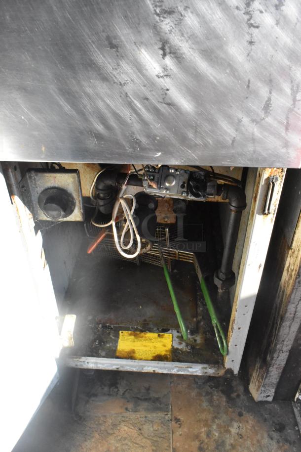 Interior view of Lanchester food trailer showing appliance mechanisms and wiring in used condition. Metal surfaces present wear.