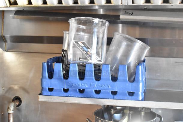 Blue Pepsi-branded rack holding clear containers inside the Lanchester food trailer. Stainless steel fixtures visible.