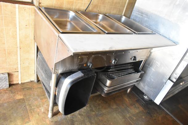 Commercial-grade ServIt steam table with three stainless steel pans in a 2007 Lanchester food trailer.