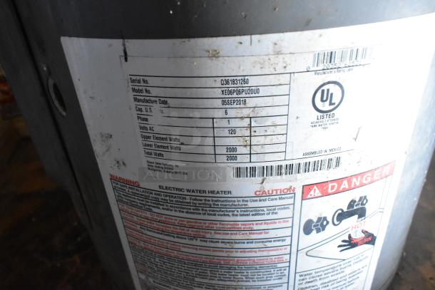 Label on electric water heater indicating model XE06P06PU20U0, manufactured on 05SEP2018, with a 6-gallon capacity and 120 volts.