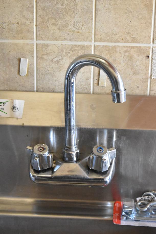 Stainless steel sink faucet in the 2007 Lanchester food trailer, featuring dual tap handles and tiled backsplash.