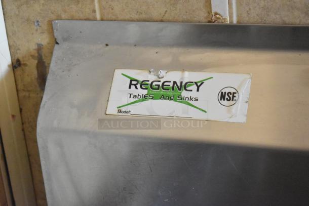 Regency stainless steel commercial table and sink with NSF label, showing durable construction in a food trailer setup.