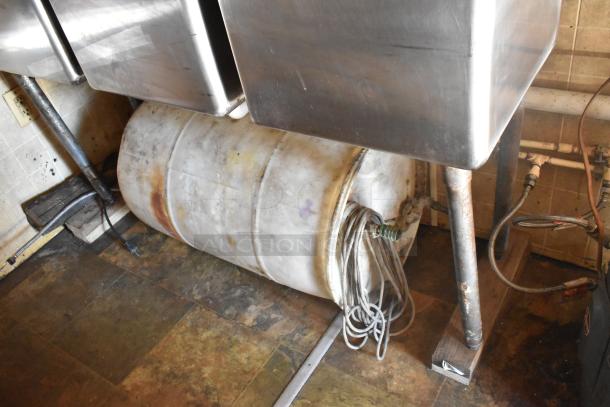2007 Lanchester food trailer interior showing stainless steel sink, industrial barrel, and plumbing fixtures.