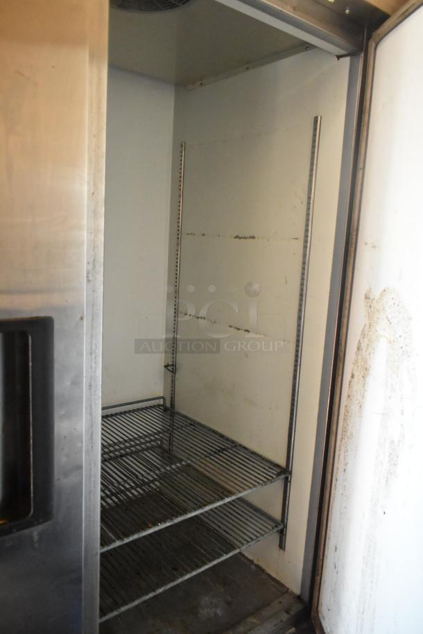 Interior view of stainless steel commercial cooler with wire shelves in a 2007 Lanchester food trailer.
