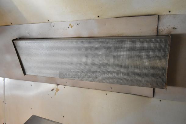 Metallic interior of a 2007 Lanchester food trailer featuring a PDI grease hood, showcasing its robust kitchen setup.