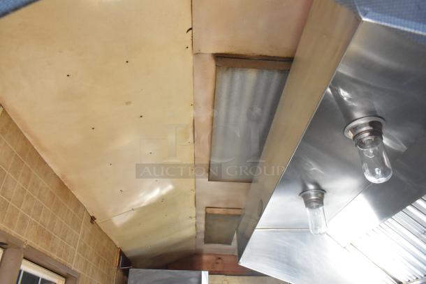 Interior of a 2007 Lanchester food trailer showing ceiling and stainless steel hood with mounted light fixtures.
