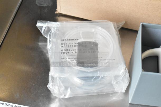 Starbucks cold-to-go cup lid in packaging, part of a lot with ceramic mugs and poly cups.