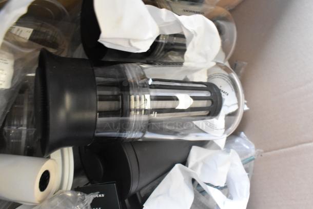 Lot of Starbucks items, including ceramic mugs and poly cups, in protective packaging. Visible Starbucks branding.