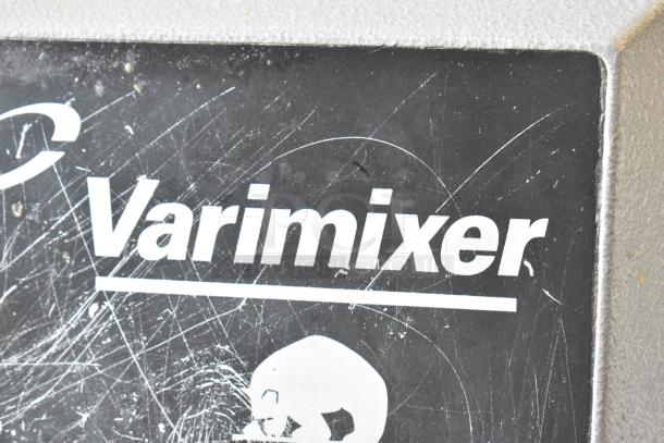 Varimixer W20 label on commercial mixer; visible wear marks on scratched metal surface.