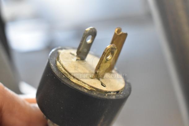 Close-up of a plug for a Varimixer W20 20-quart planetary dough mixer, showing three prongs.