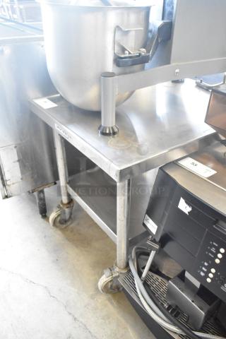 Stainless steel commercial mixer stand with attachment rod, metal under shelf, on commercial casters, used condition.
