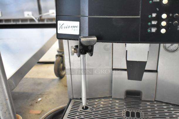 Schaerer Verismo 701 metal commercial automatic espresso machine with 2 hoppers, visible control panel, and branding label.