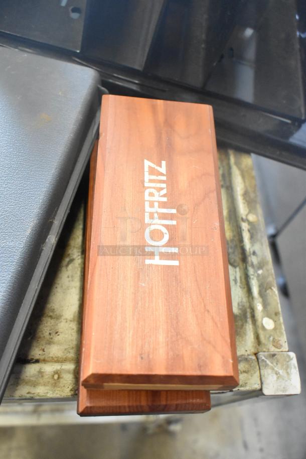 Wooden box with "Hoffritz" label, placed on a metal surface.