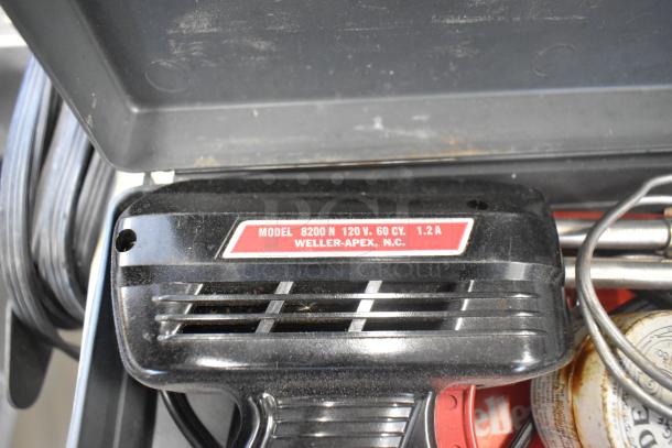 Metal 4 tier cart with commercial casters, sturdy design. Black frame, shelves show wear. No visible labels or tags.