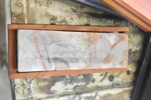 Marble texture art piece in a wooden frame, featuring gray and rust-like patterns. Oxidized metal surface background.