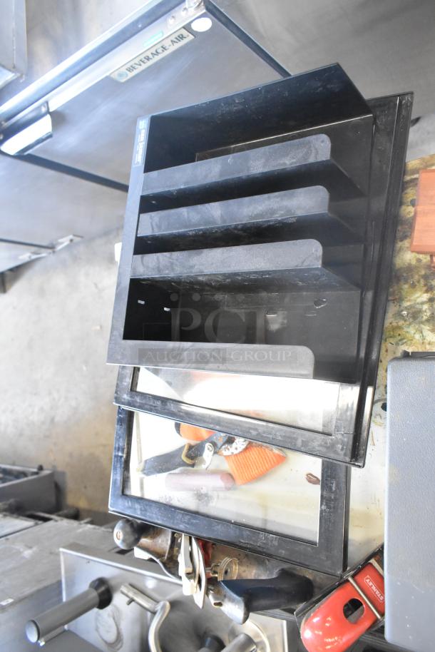 4 Tier Metal Cart on commercial casters, black, appears used, includes trays for organizing, durable construction.