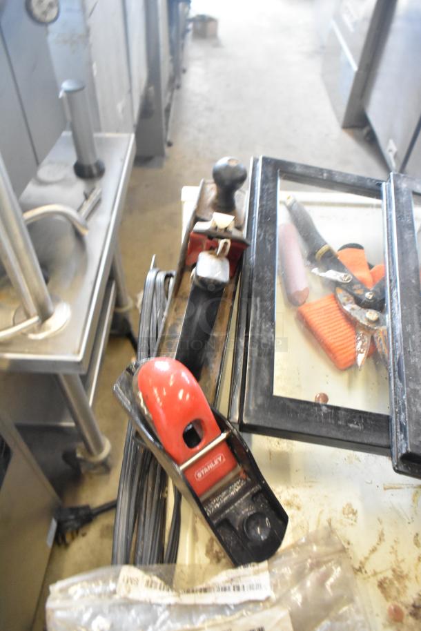 Metal 4 tier cart on commercial casters, sturdy, industrial design, some visible tools and equipment on top, used condition.