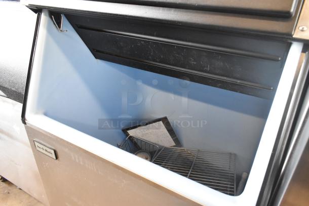 Follett B55H22H30 stainless steel ice head on Ice-O-Matic B55PSC ice bin, commercial use, minimal wear, Ice-O-Matic label visible.
