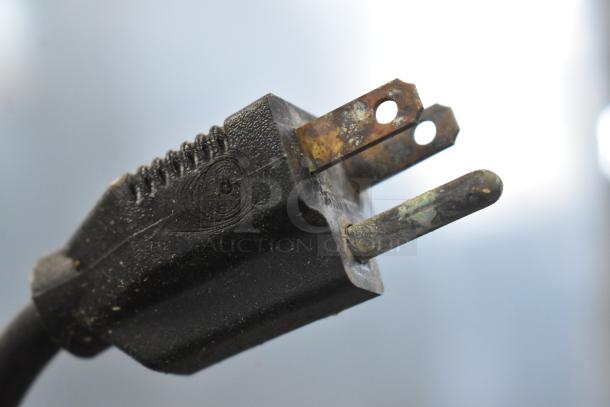 A close-up of a rusted metal plug with visible oxidation and wear.