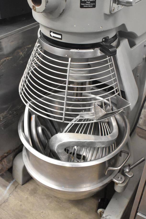 Globe SP40 metal 40-quart planetary dough mixer with stainless steel bowl, bowl guard, whisk, paddle, and dough hook attachments.