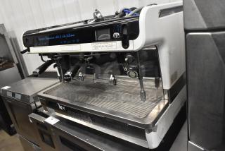Faema Teorema stainless steel commercial espresso machine with 2 groups, 3 portafilters, and 2 steam wands, good condition.